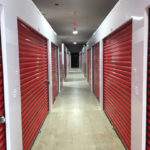 Bright white corridor system with patriot red doors in a self-storage conversion.  