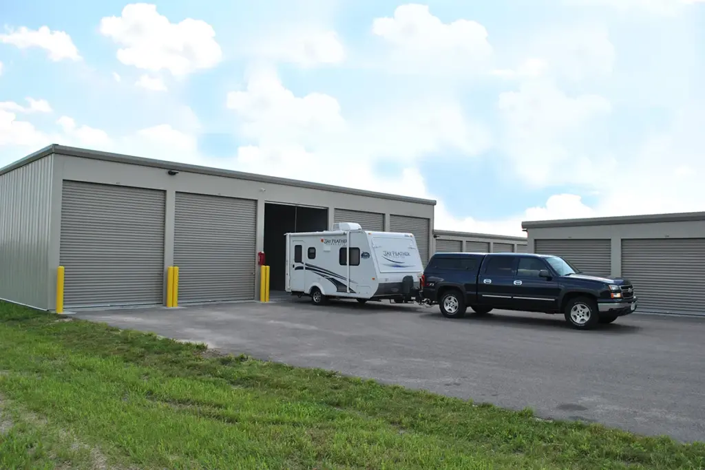truck backing in camper into storage unit