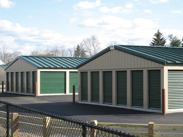 Classic beige self-storage buildings with evergreen doors. Roofs are evergreen standing seam with a 3:12 pitch.