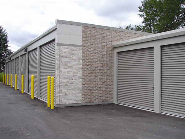 One-story slate gray self-storage buildings with shale doors. Exterior facade Nichiha brand fiber cement products.