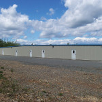 Slate gray self-storage facility with polar blue doors and standing seam roof. 