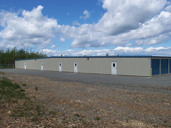 Slate gray self-storage facility with polar blue doors and standing seam roof. 