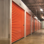 Conversion with car/boat storage, sunset orange doors and indoor drive-thru loading area.