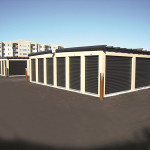 Classic beige low pitch self-storage buildings with matte black doors.