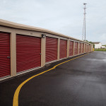 Classic beige self-storage buildings with rolling steps and cedar red doors. 