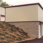 Two-story self-storage building built into a hillside. The end wall and back wall of the upper level are metal.