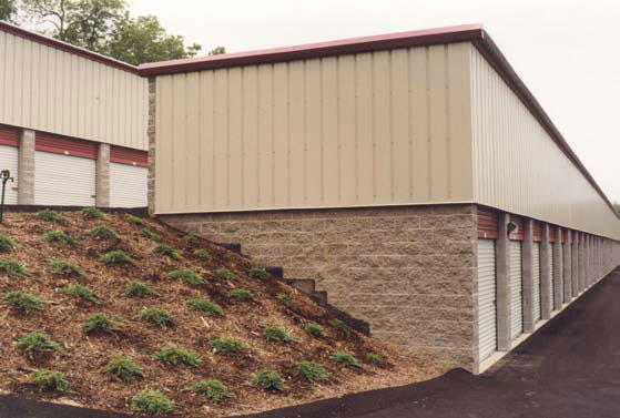 Two-story self-storage building built into a hillside. The end wall and back wall of the upper level are metal.