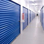 A brightly lit corridor with royal blue doors.