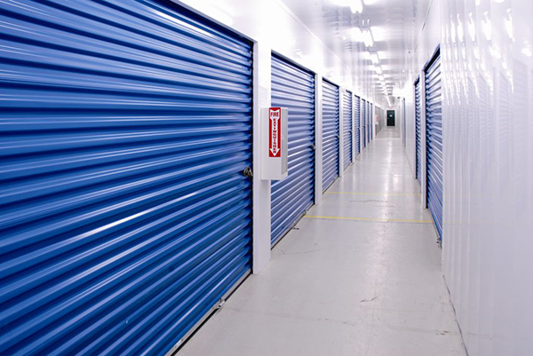 A brightly lit corridor with royal blue doors.